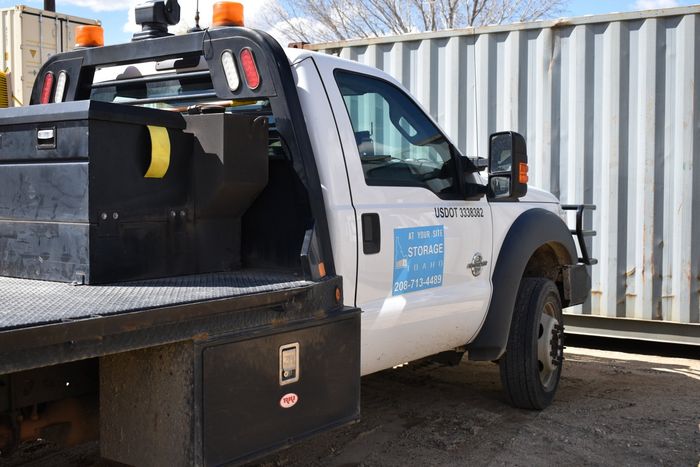 White tow truck near container