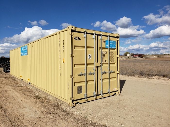 Yellow shipping container on dirt